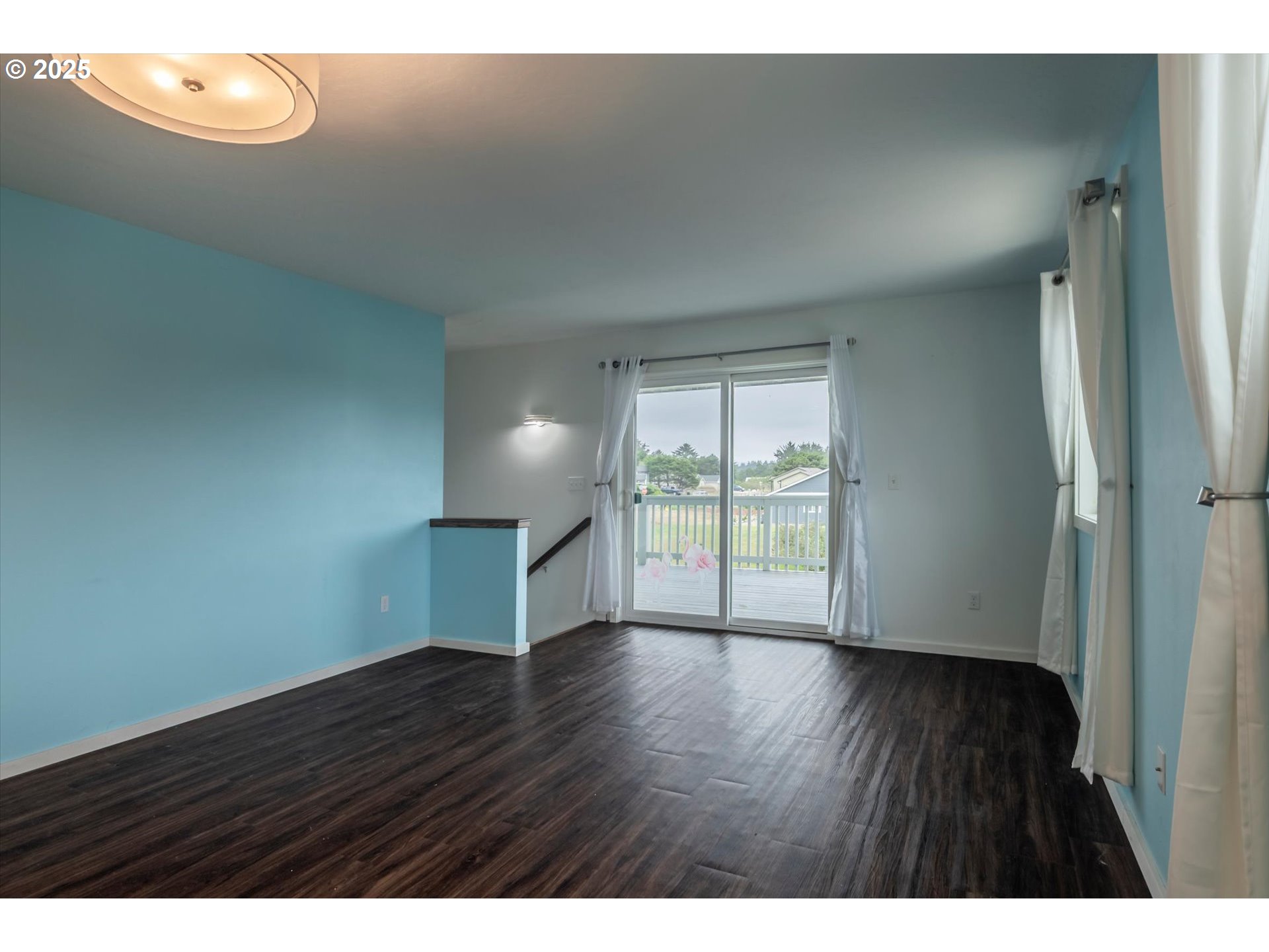 3145 Periwinkle Lane Southwest Bandon, OR 97411 - Photo 6 of 26 a view of an empty room with wooden floor and a window