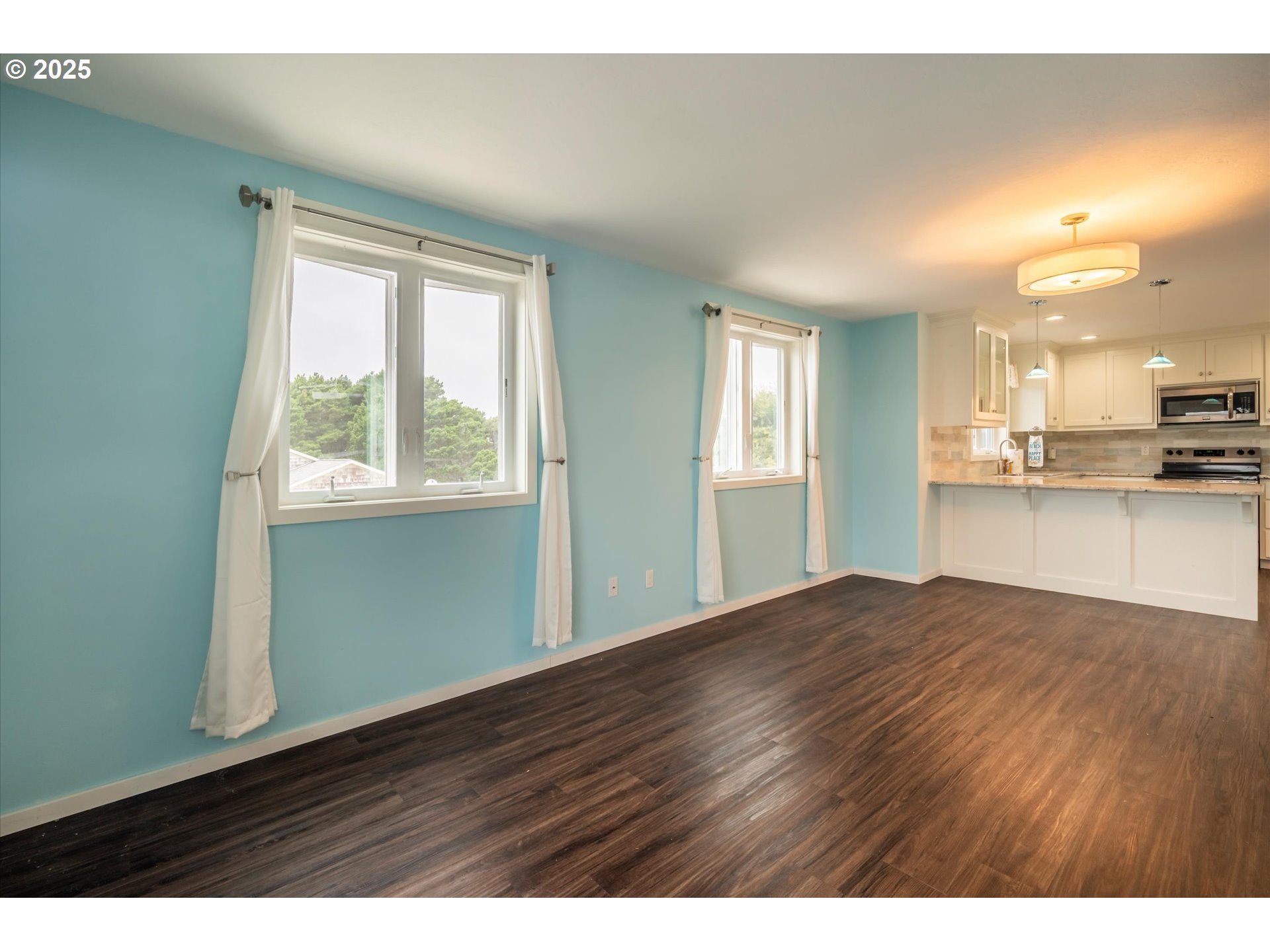 3145 Periwinkle Lane Southwest Bandon, OR 97411 - Photo 7 of 26 a view of an empty room with window and wooden floor