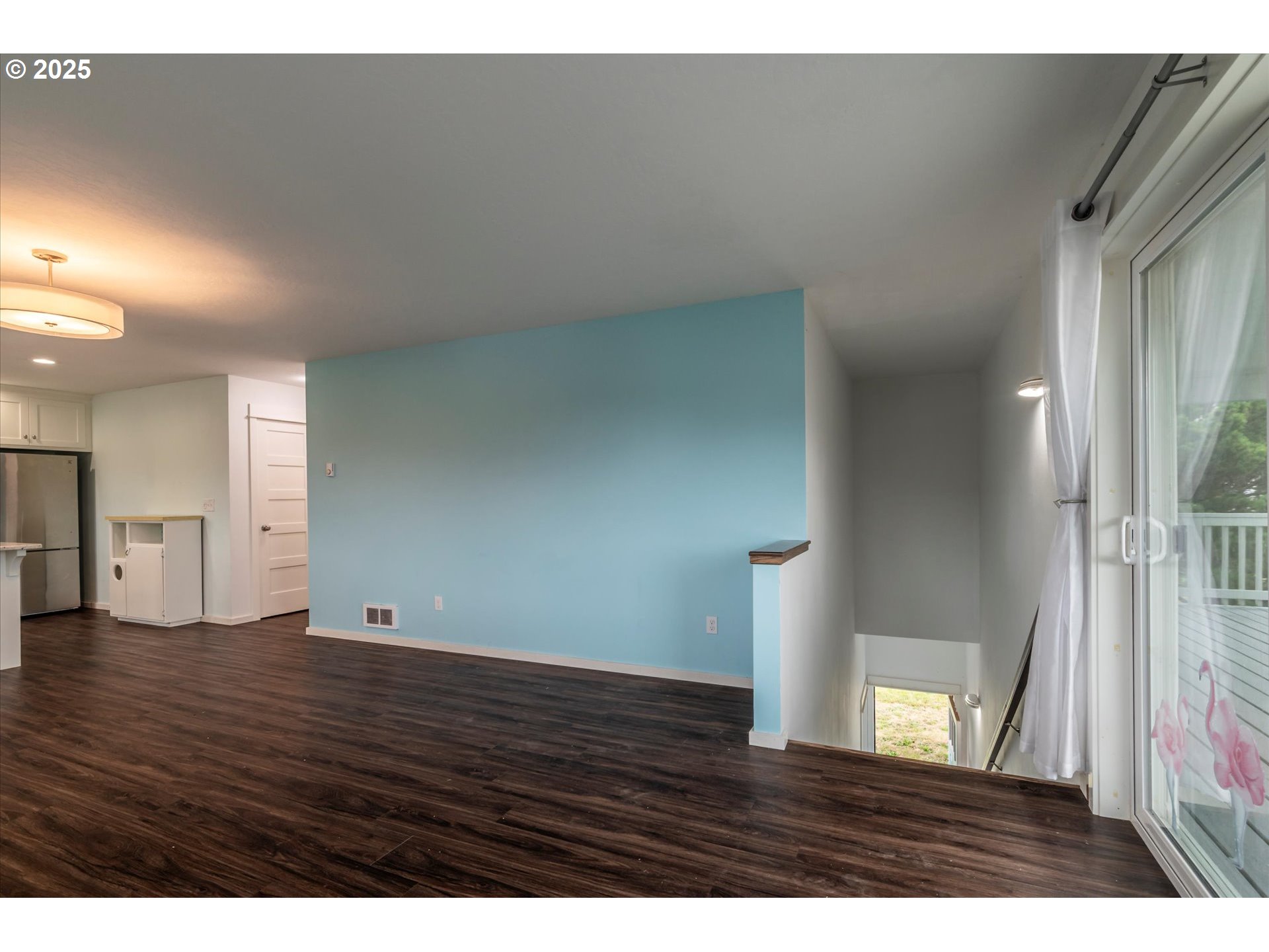 3145 Periwinkle Lane Southwest Bandon, OR 97411 - Photo 8 of 26 a view of an empty room with wooden floor and a window