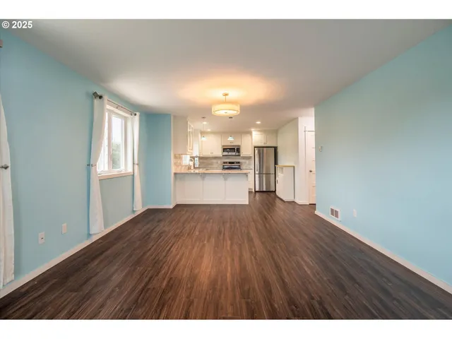 a view of a kitchen with a sink and a refrigerator