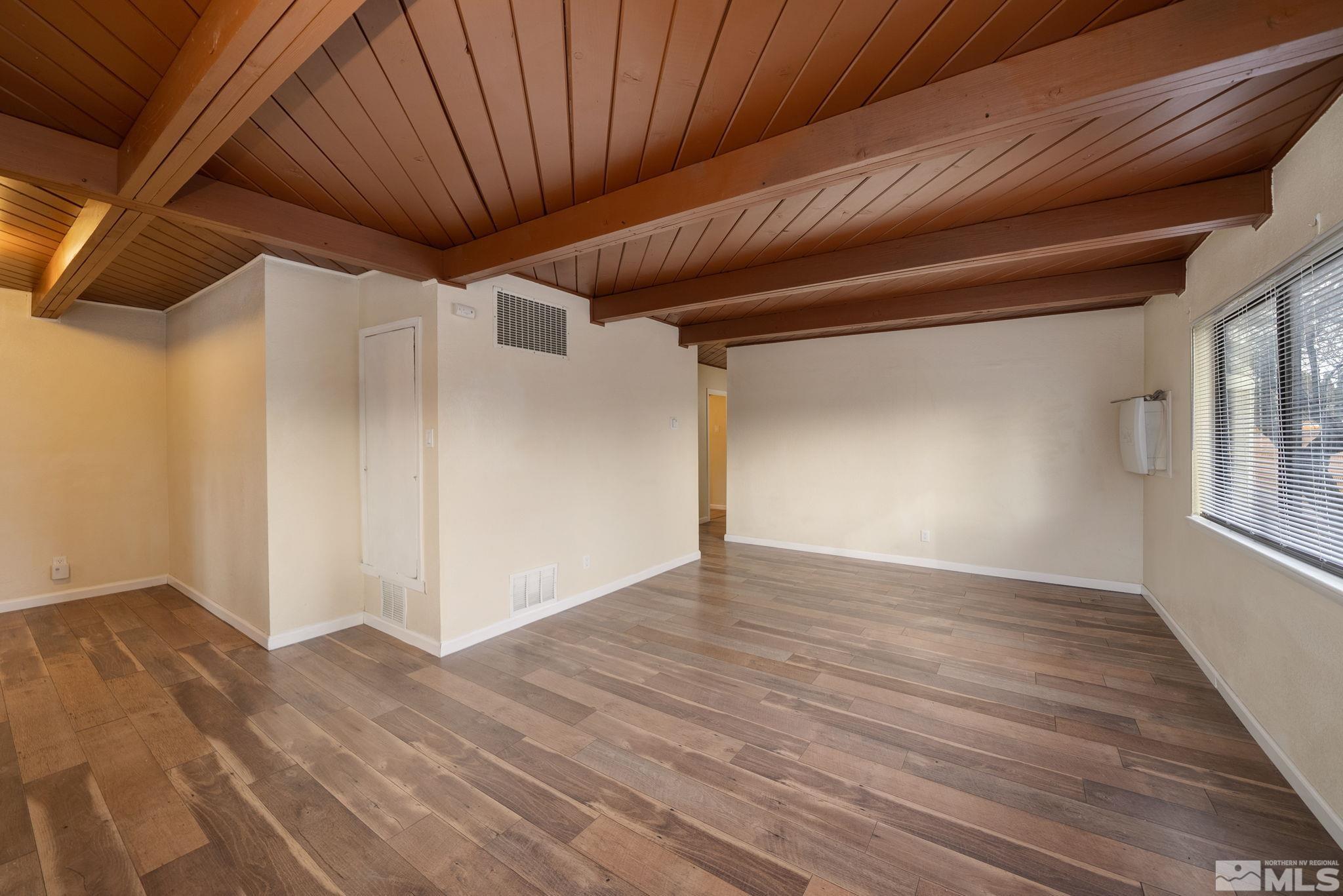 1680 Sterling Way Reno, NV 89512 - Photo 3 of 20 a view of an empty room with wooden floor and a window