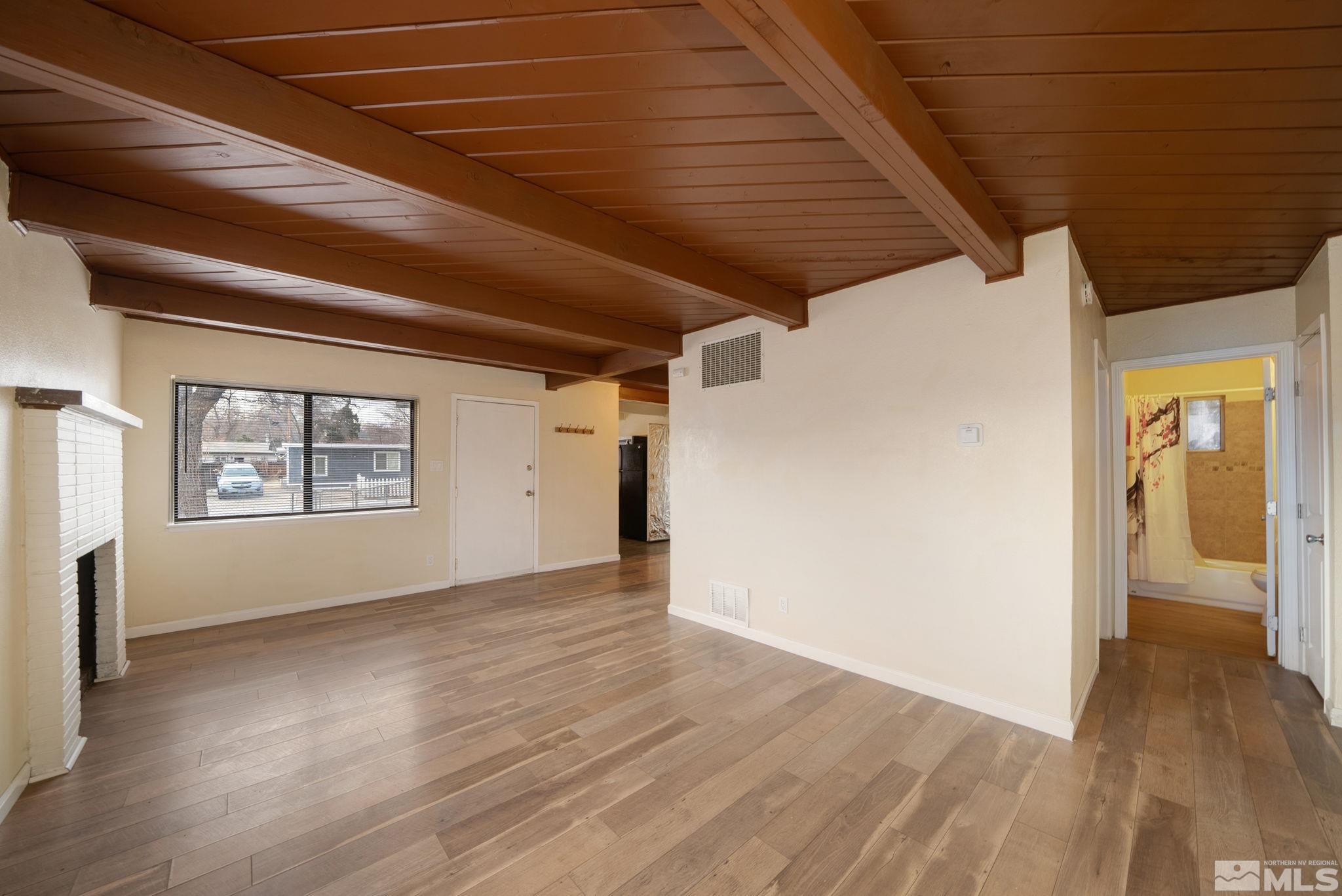 1680 Sterling Way Reno, NV 89512 - Photo 4 of 20 a view of an empty room with wooden floor and a window