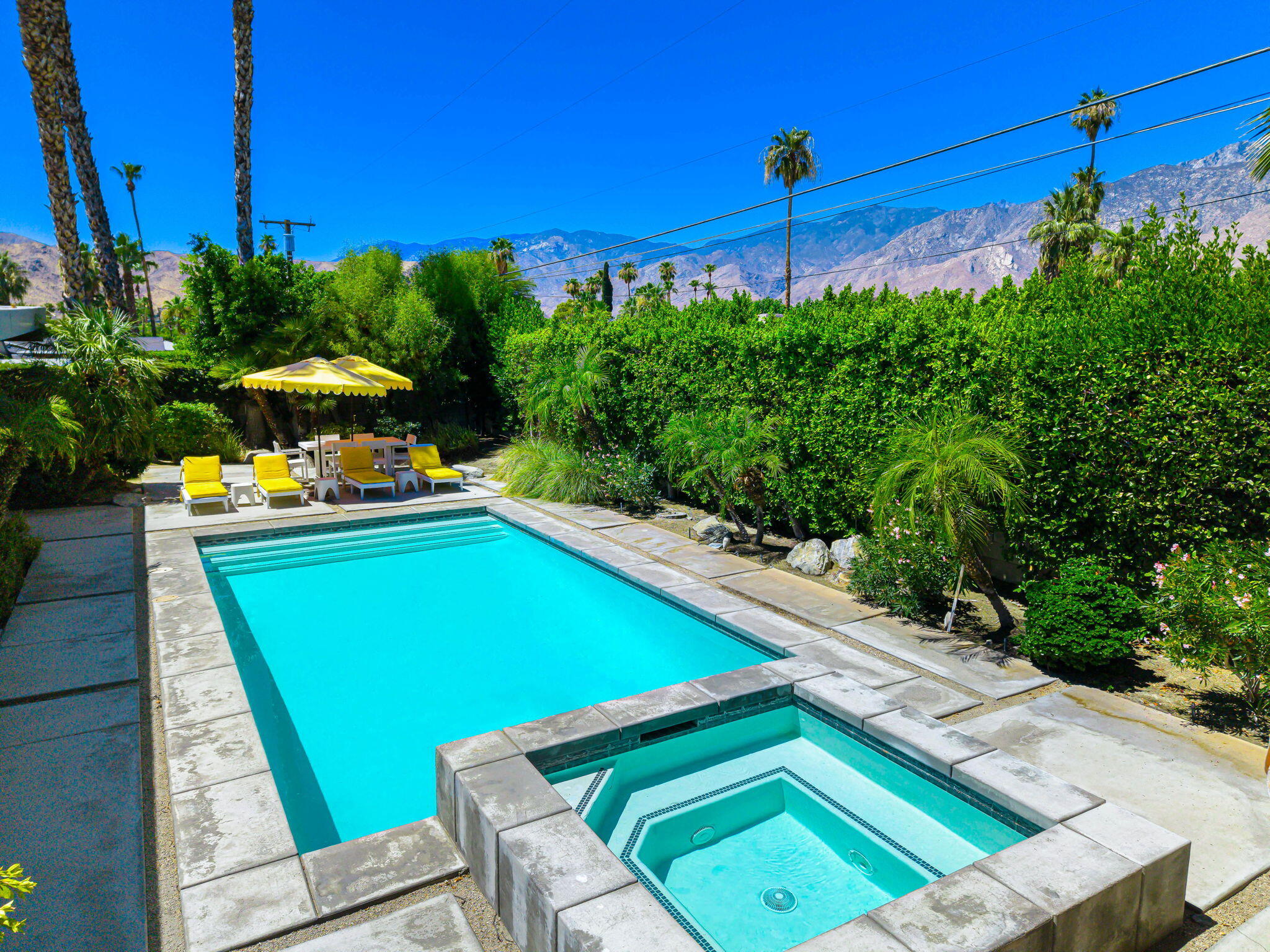 623 Desert Way Palm Springs, CA 92264 - Photo 20 of 39 a view of a tennis ground with a table and chairs under an umbrella