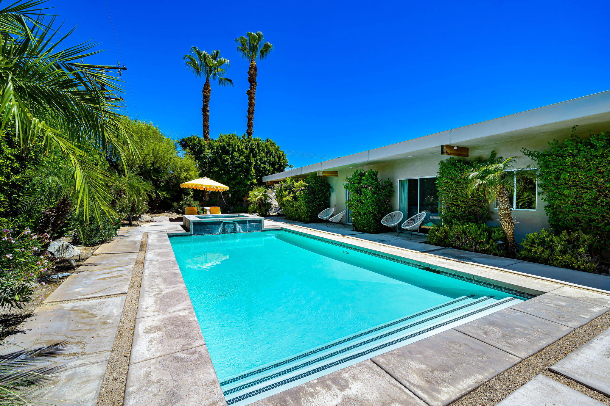 623 Desert Way Palm Springs, CA 92264 - Photo 26 of 39 a view of a pool with a table and chairs under an umbrella