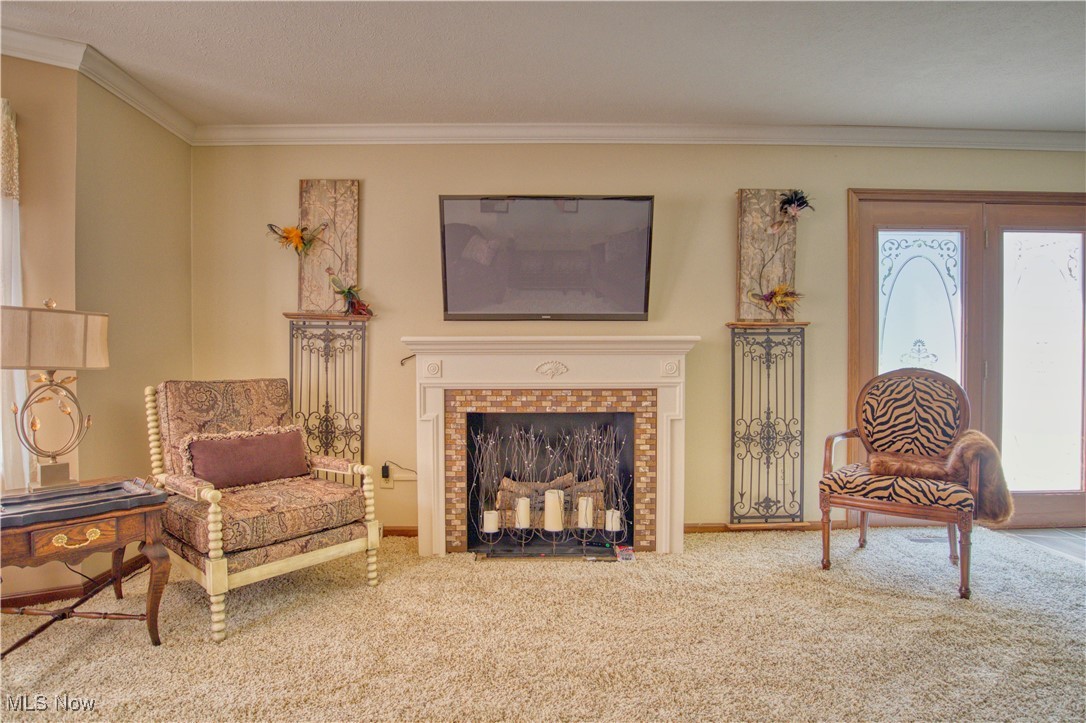 7017 Kirk Road Canfield, OH 44406 - Photo 13 of 35 Living area with crown molding, carpet floors, and a tiled fireplace