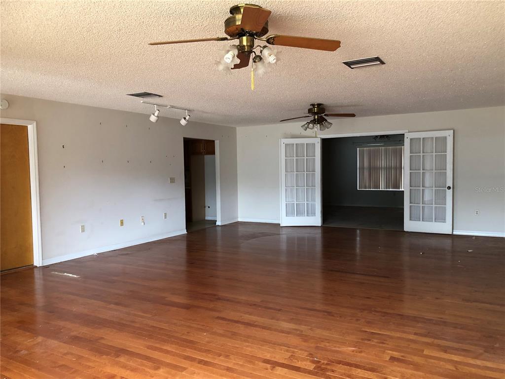 34847 Learn Road Leesburg, FL 34788 - Photo 7 of 42 a view of a livingroom with a ceiling fan and wooden floor