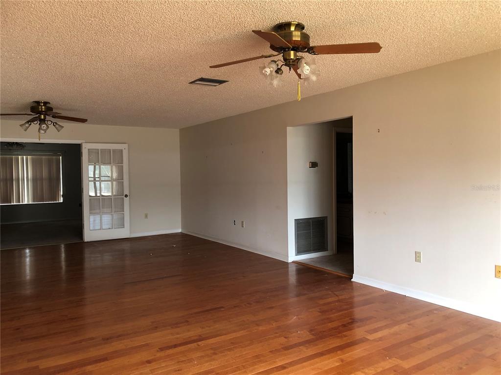 34847 Learn Road Leesburg, FL 34788 - Photo 8 of 42 a view of an empty room with a window and wooden floor