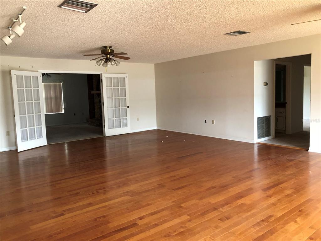 34847 Learn Road Leesburg, FL 34788 - Photo 9 of 42 a view of an empty room with wooden floor and a ceiling fan