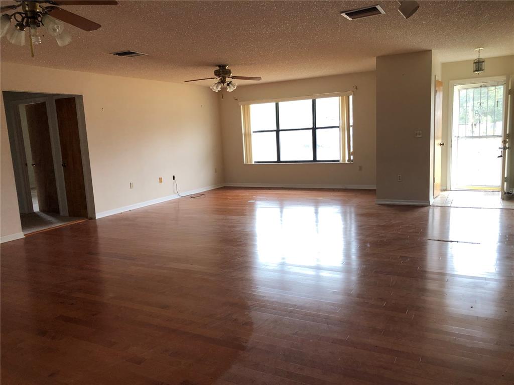 34847 Learn Road Leesburg, FL 34788 - Photo 10 of 42 an empty room with wooden floor and windows