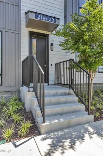 a view of a house with a small yard plants and wooden fence