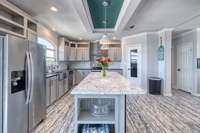 a kitchen with stainless steel appliances granite countertop a refrigerator and a sink