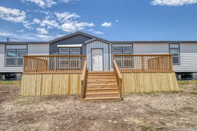 a view of a house with a wooden fence