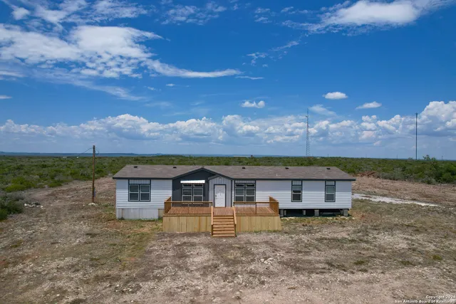 a view of a big house in the middle of a yard