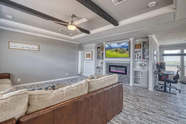 a living room with furniture a flat screen tv and a fireplace