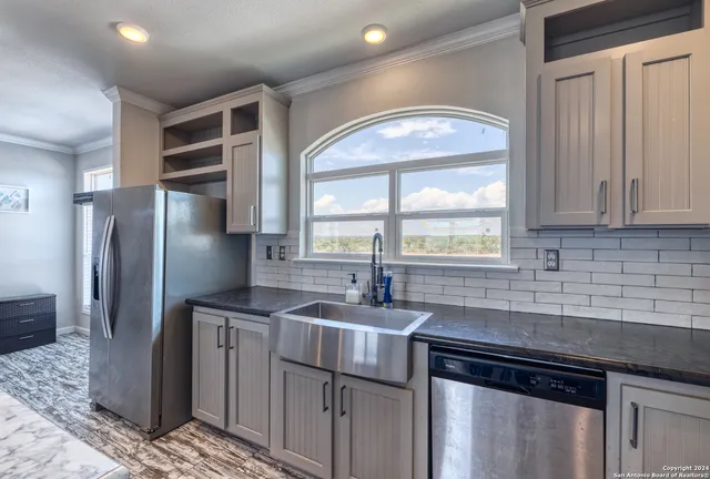 a kitchen with stainless steel appliances granite countertop a sink stove and refrigerator