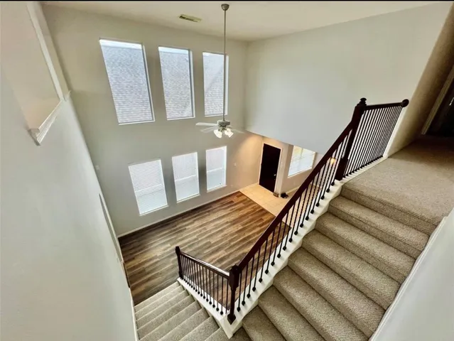 a view of staircase with lots of frames on wall and a window