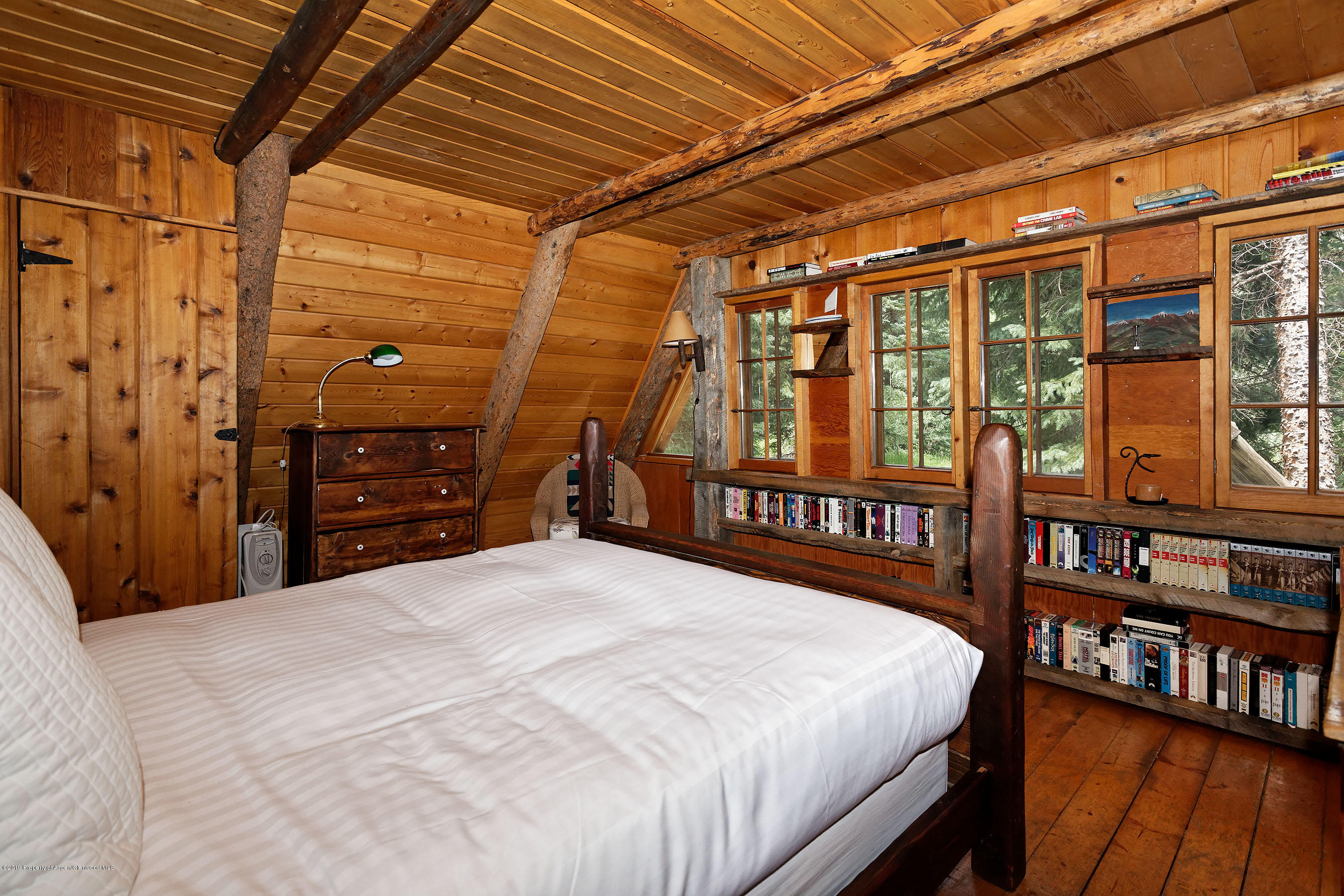 245-289 Conundrum Creek Road Aspen, CO 81611 - Photo 22 of 28 a large bed sitting in a bedroom next to a book shelf