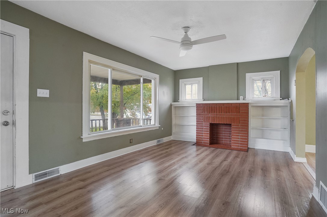 888 Dan Street Akron, OH 44310 - Photo 8 of 36 Unfurnished living room featuring hardwood / wood-style floors, plenty of natural light, ceiling fan, and a fireplace