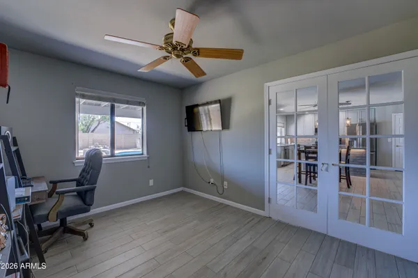 a view of a workspace with wooden floor and a window