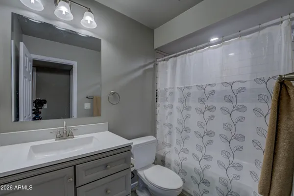 a bathroom with a granite countertop sink a toilet and a mirror