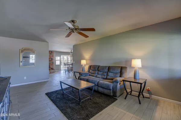 a living room with furniture a lamp and wooden floor