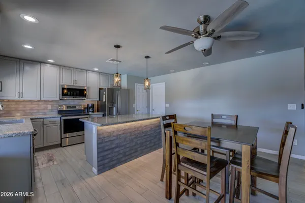 a kitchen with a table chairs refrigerator and microwave