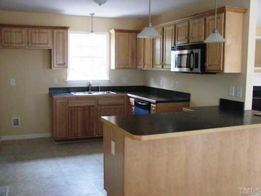 BEAUTIFUL KITCHEN LOADED WITH TONS OF CABINETS AND STAINLESS STEEL APPLIANCES.