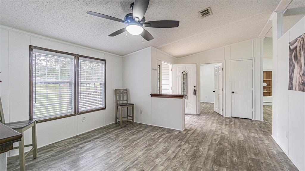 7029 Forbes Road Zephyrhills, FL 33540 - Photo 12 of 53 a view of empty room with wooden floor and fan