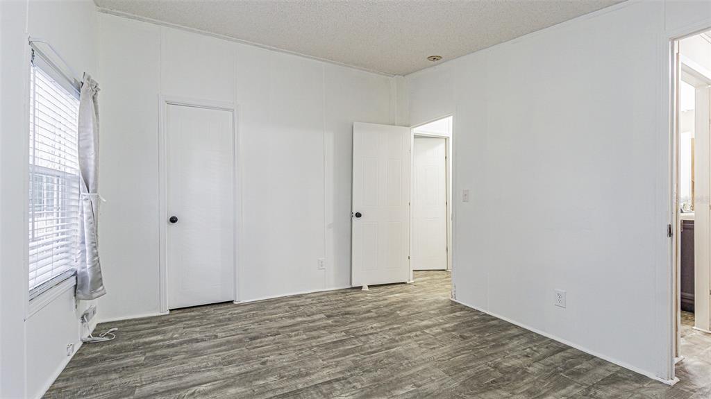 7029 Forbes Road Zephyrhills, FL 33540 - Photo 29 of 53 a view of an empty room with wooden floor and a window