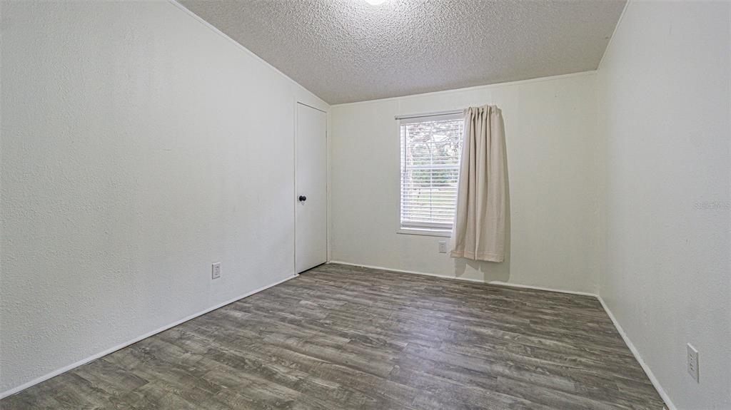 7029 Forbes Road Zephyrhills, FL 33540 - Photo 30 of 53 wooden floor in an empty room with a window