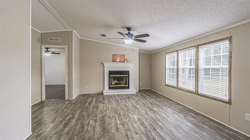 7029 Forbes Road Zephyrhills, FL 33540 - Photo 9 of 53 a view of an empty room with a window and a kitchen