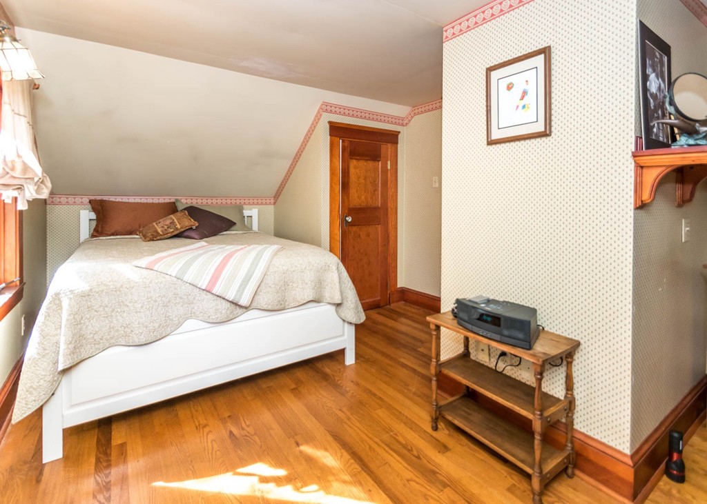 29 Virginia Road Waltham, MA 02453 - Photo 13 of 19 a bedroom with a bed and wooden floor