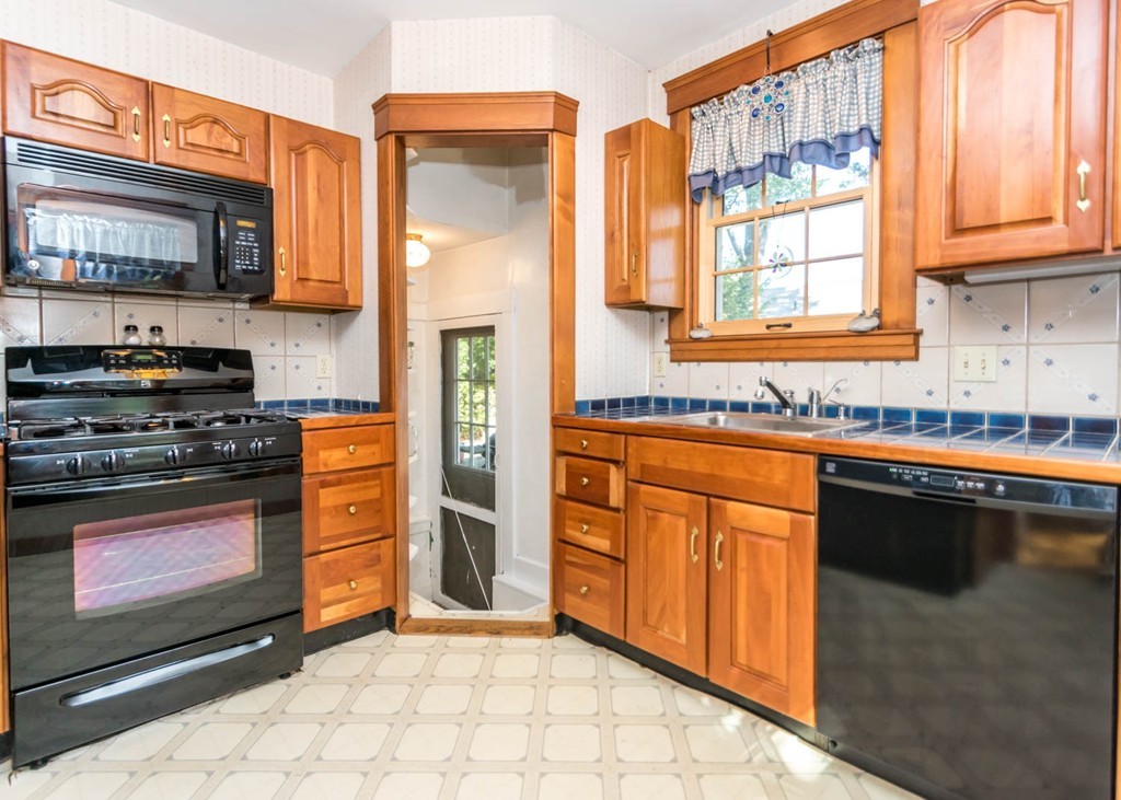 29 Virginia Road Waltham, MA 02453 - Photo 8 of 19 a kitchen with stainless steel appliances granite countertop a stove a sink and a microwave
