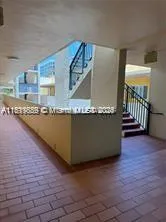 a living room with granite countertop a sink and a wooden floor
