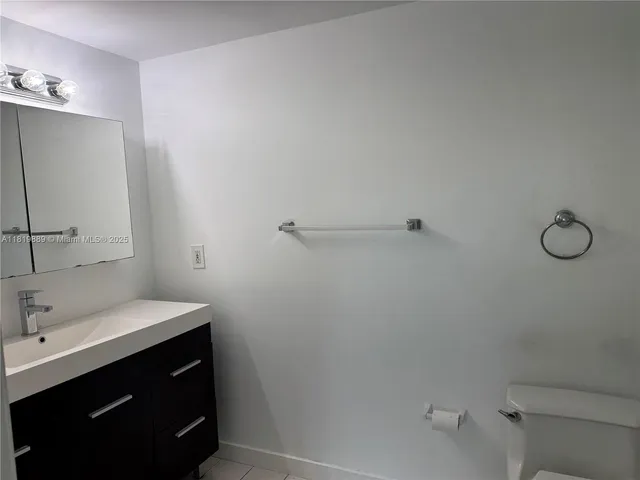 a bathroom with a sink vanity and toilet