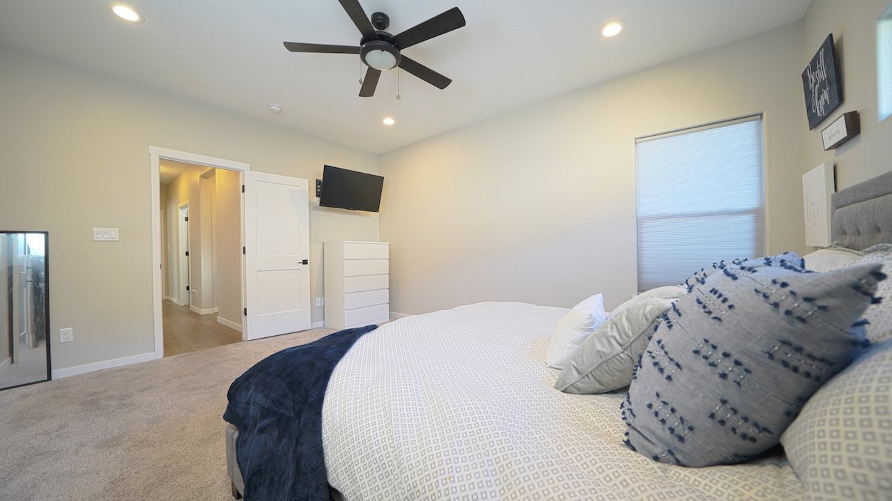 2476 Zenith Lane, Unit B Grand Junction, CO 81505 - Photo 11 of 24 a bedroom with a large bed and chandelier
