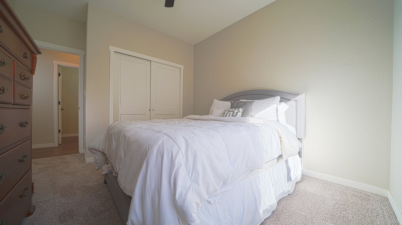 2476 Zenith Lane, Unit B Grand Junction, CO 81505 - Photo 14 of 24 a bedroom with a bed and a refrigerator