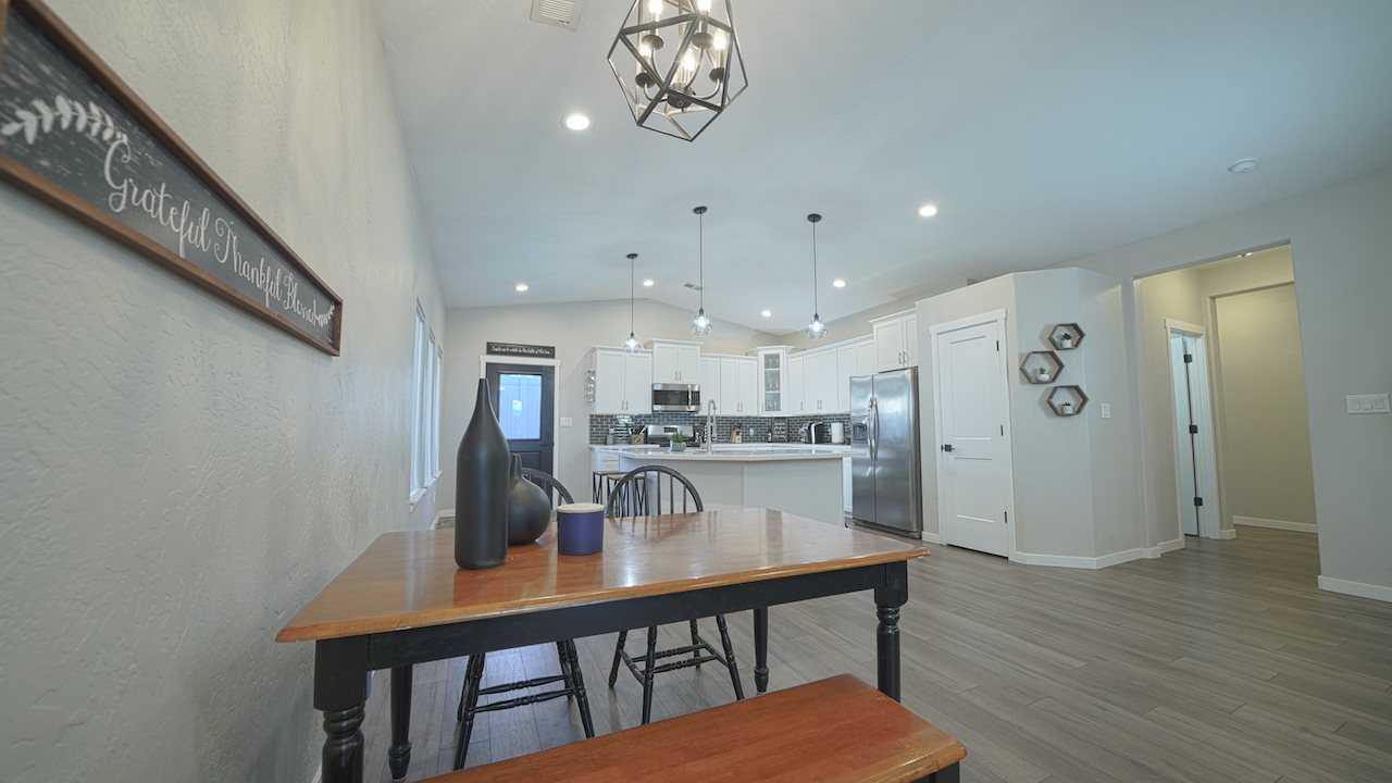 2476 Zenith Lane, Unit B Grand Junction, CO 81505 - Photo 5 of 24 a kitchen with stainless steel appliances granite countertop a kitchen island a stove a table and chairs