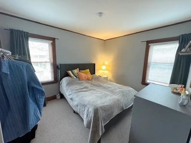 a bedroom with a bed lamp and a large window