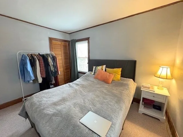 a bed sitting in a bedroom next to a window