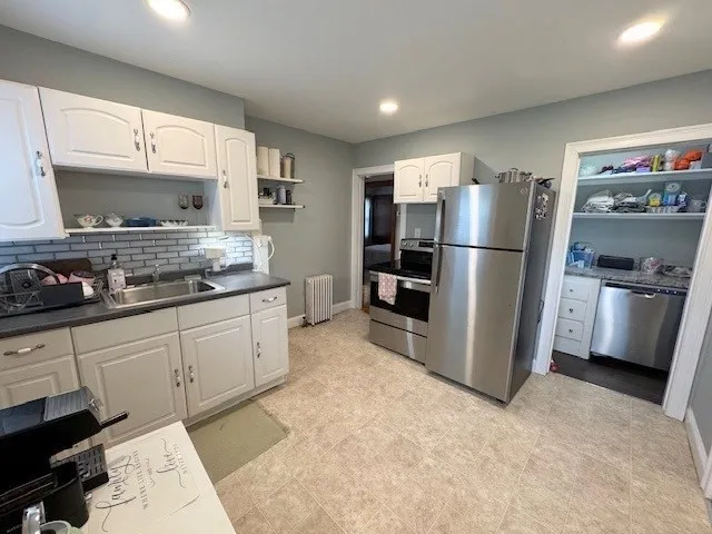 a kitchen with refrigerator a microwave a stove and cabinets