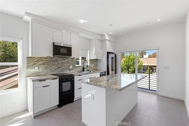 a kitchen with stainless steel appliances granite countertop a stove and a sink