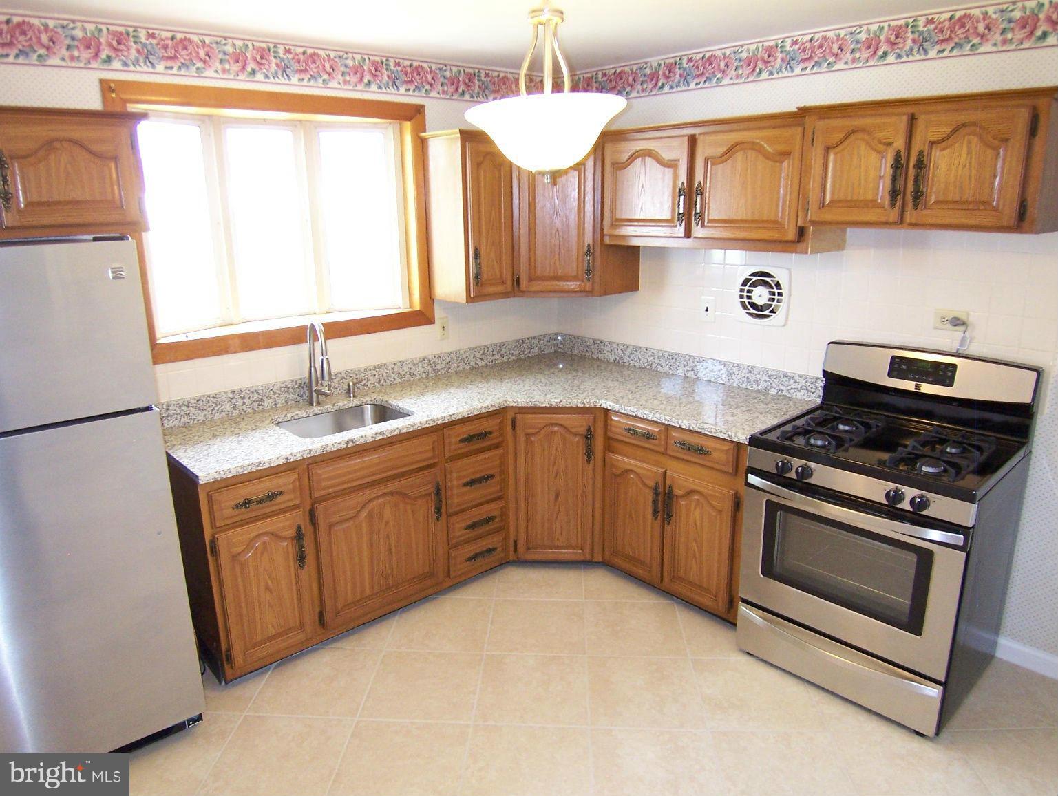 1505 Cavel Road Rosedale, MD 21237 - Photo 12 of 27 a kitchen with stainless steel appliances granite countertop a sink and a stove