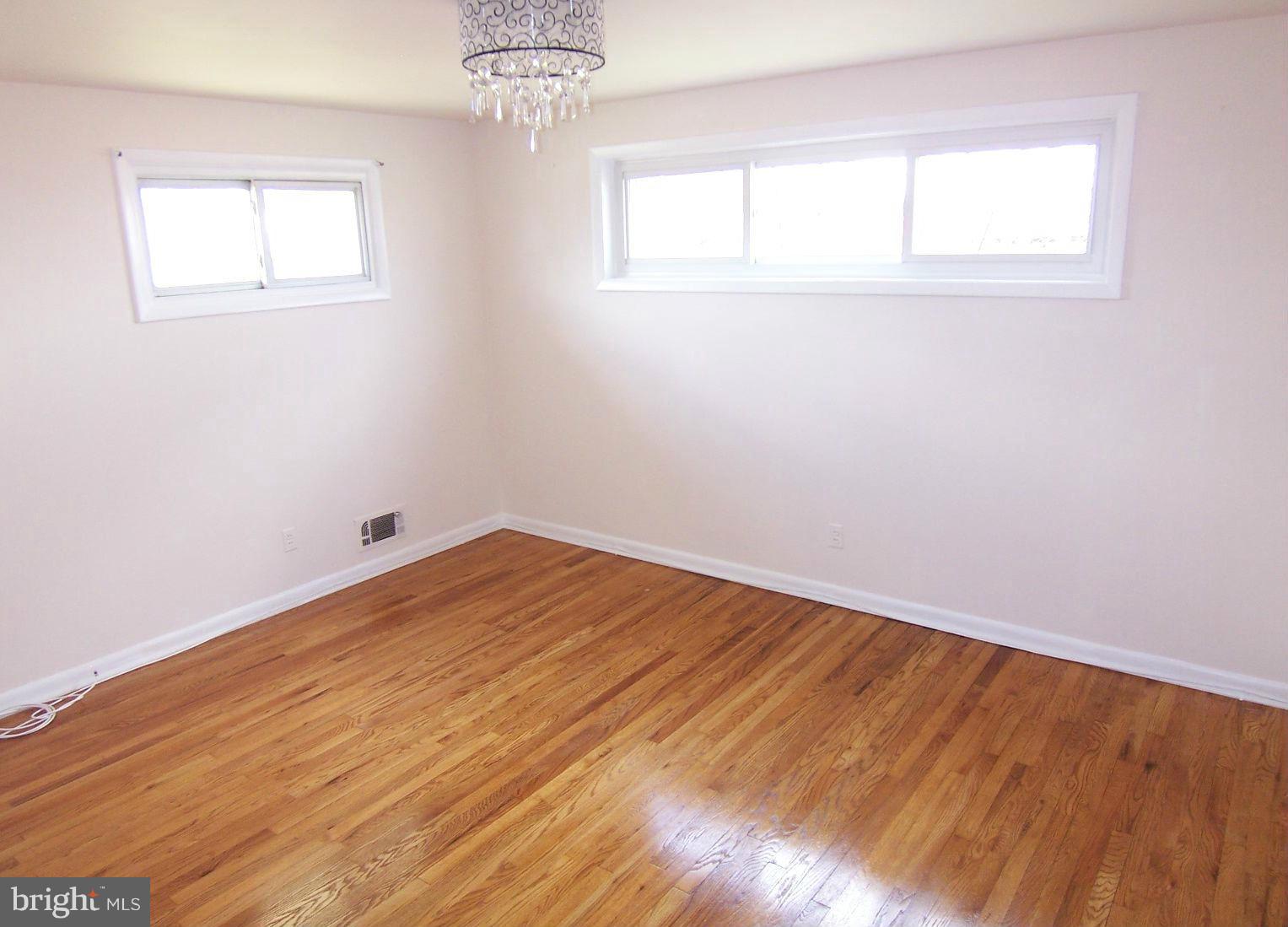 1505 Cavel Road Rosedale, MD 21237 - Photo 16 of 27 an empty room with wooden floor and windows