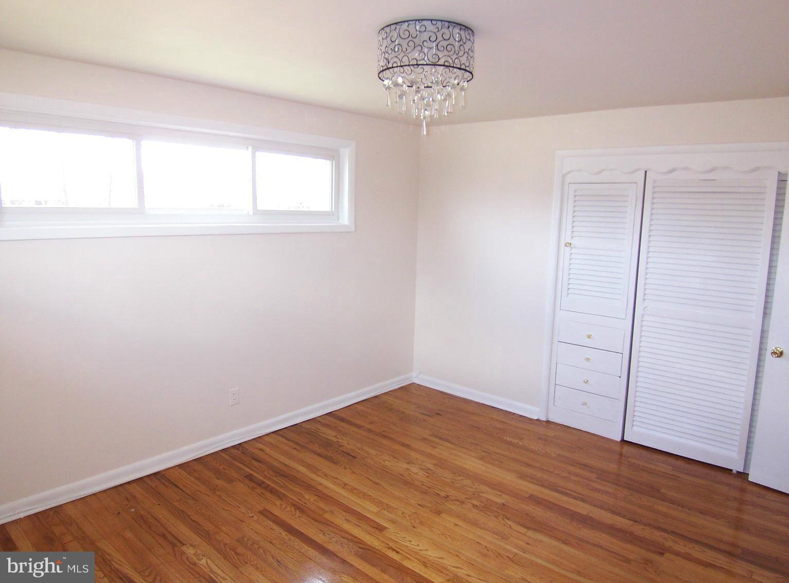 1505 Cavel Road Rosedale, MD 21237 - Photo 17 of 27 an empty room with wooden floor and window