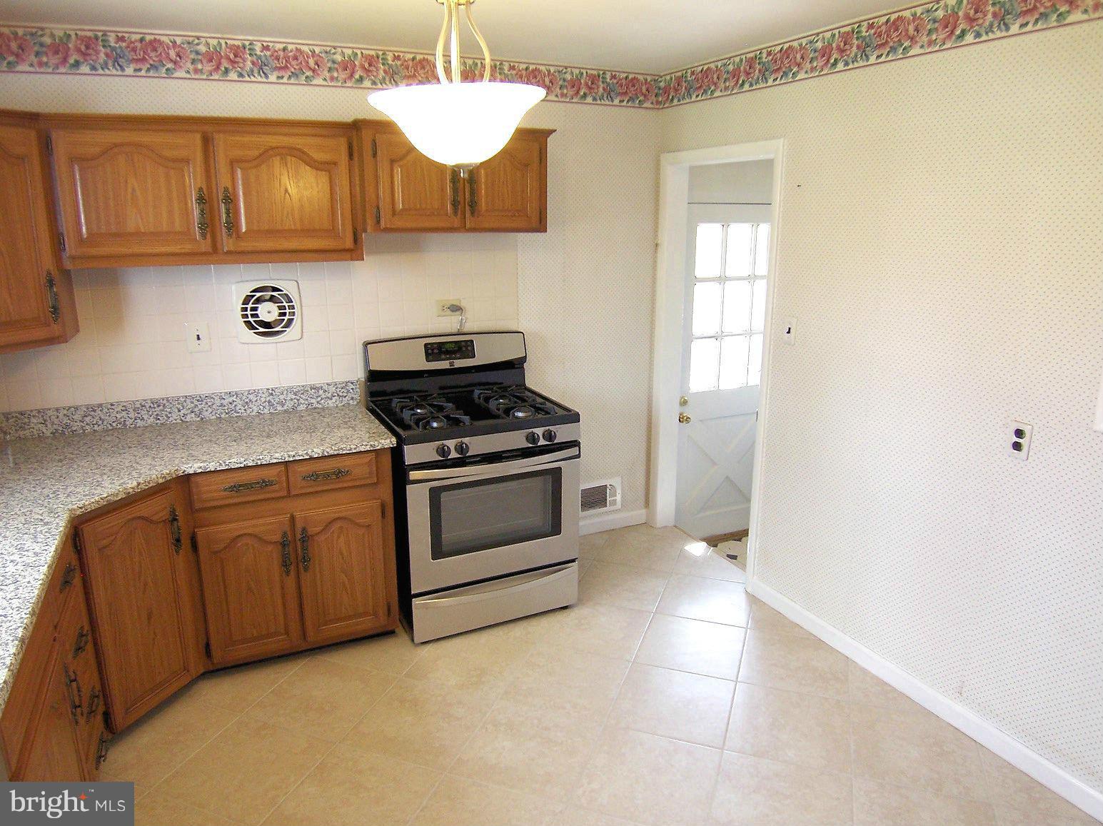 1505 Cavel Road Rosedale, MD 21237 - Photo 9 of 27 a kitchen with stainless steel appliances a stove a sink and cabinets