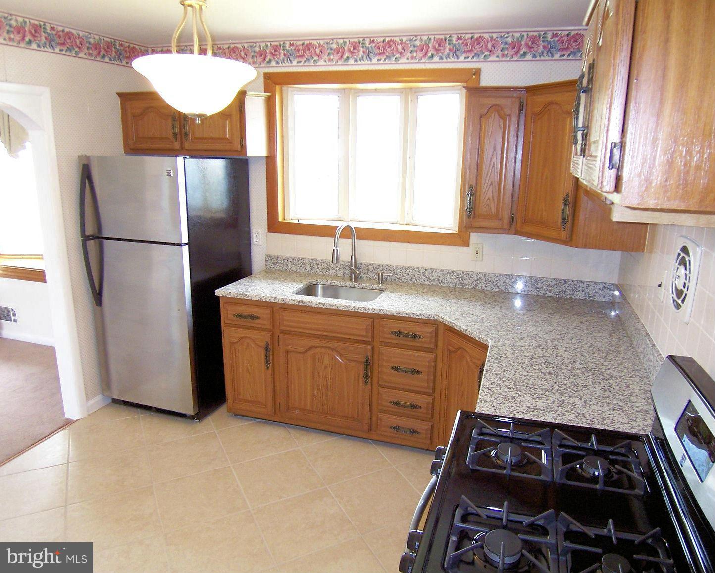 1505 Cavel Road Rosedale, MD 21237 - Photo 10 of 27 a kitchen with a sink stove and refrigerator