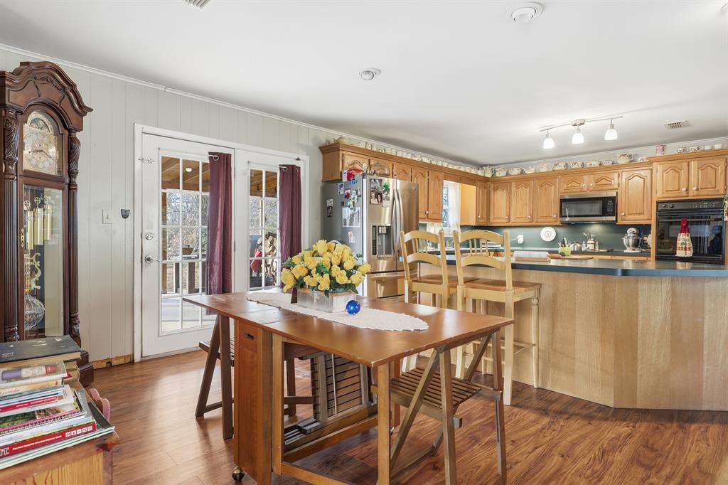 240 Fm 3421 Daingerfield, TX 75638 - Photo 10 of 27 a kitchen with stainless steel appliances kitchen island granite countertop a refrigerator a stove top oven and a dining table with wooden floor