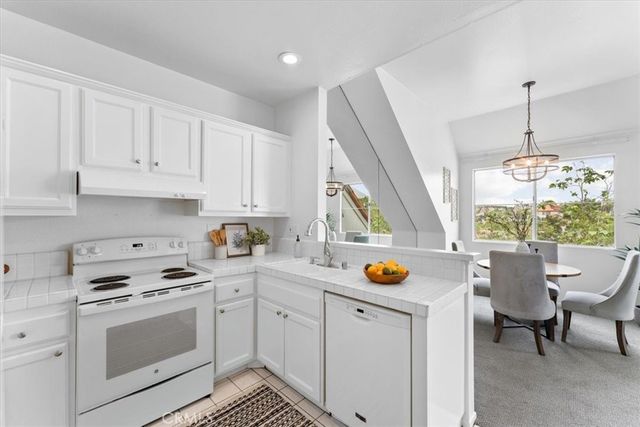 a kitchen with a white wooden cabinets and white appliances