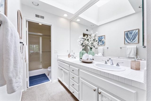 a bathroom with double vanity sink and a mirror